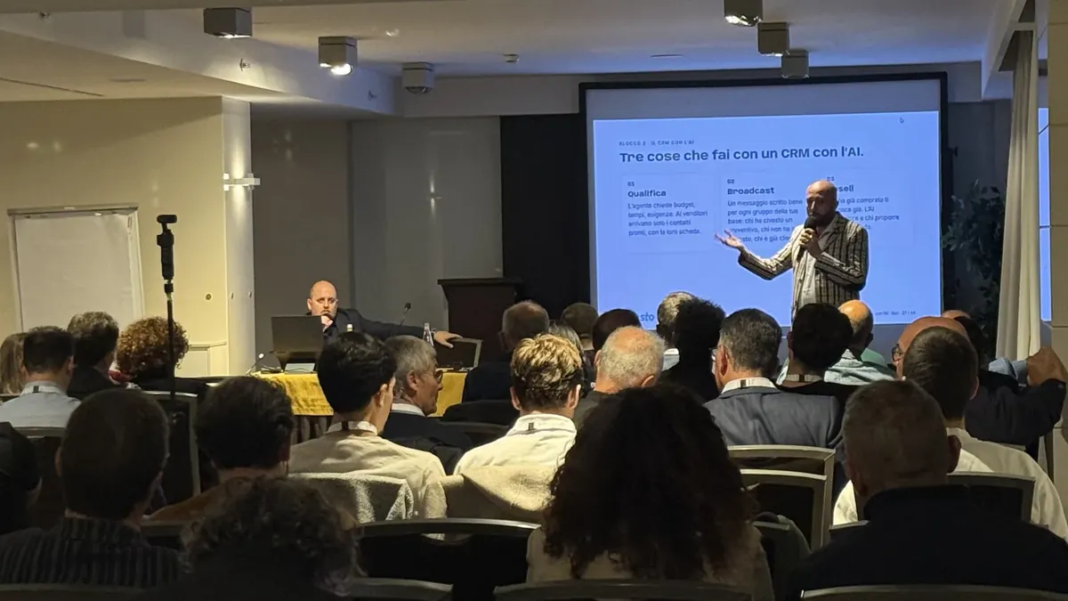 La sala di Bari durante la serata del 21 ottobre: il relatore davanti alla slide e la platea